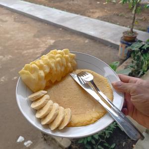 a plate of food with pancakes and bananas on it at Tetebatu Clove Garden in Tetebatu