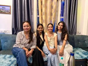 a group of four women sitting on a couch at The Basecamp Dorm in Siliguri