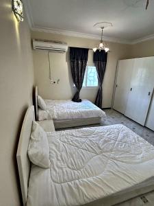 a bedroom with two beds and a window at شقة مدخل خاص بمدخلين in Tanomah