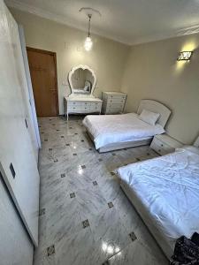 a bedroom with two beds and a chair at شقة مدخل خاص بمدخلين in Tanomah