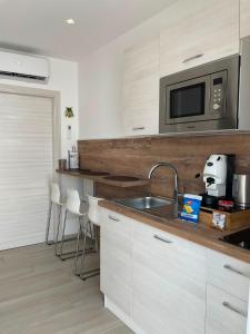 a kitchen with a sink and a microwave at Home-Carrara in Naples