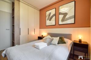 a bedroom with a white bed with two lamps on it at Cavallia Garden by LookAp - parking w garażu, ogródek in Poznań
