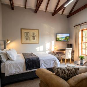 a bedroom with a bed and a table with a chair at CView Suites & Apartments in Pretoria