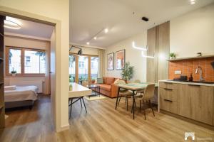 a room with a kitchen and a living room at Cavallia Garden by LookAp - parking w garażu, ogródek in Poznań +19 photos