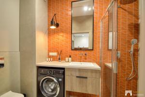 a bathroom with a washing machine and a sink at Cavallia Garden by LookAp - parking w garażu, ogródek in Poznań
