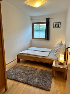 a bed in a room with a window and a rug at Ferienwohnung am Lindenweg in Brixen im Thale