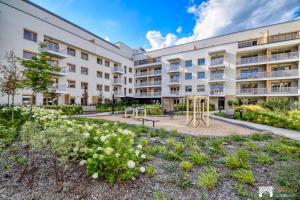 an apartment building with a playground in the courtyard at Cavallia Garden by LookAp - parking w garażu, ogródek in Poznań