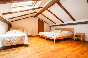 two beds in a room with wooden floors at Posestvo Laz - The Laz Estate in Voglarji