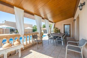 a patio with a table and chairs and a pool at Los tres soles in Portocolom