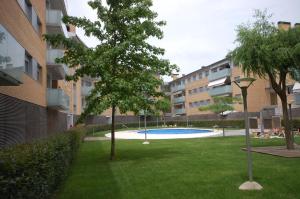 um quintal com uma árvore e uma piscina em Lets Holidays BEAUTIFUL APARTMENT w/ POOL TOSS em Tossa de Mar