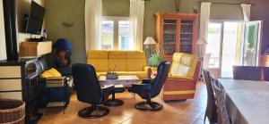 a living room with a yellow couch and chairs at Villa des Cammaous in Vacquières