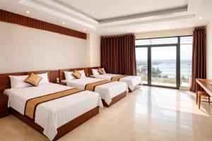 a hotel room with three beds and a balcony at Hottel HÙNG PHƯƠNG cô tô in Đảo Cô Tô