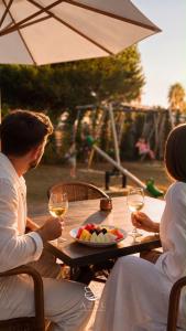 a man and a woman sitting at a table with wine glasses at Azel Boutique Hotel in Draç +23 photos