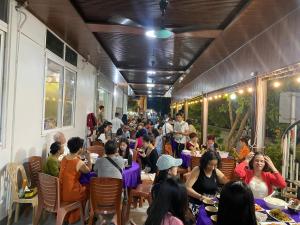 a group of people sitting at tables in a restaurant at Hottel HÙNG PHƯƠNG cô tô in Đảo Cô Tô