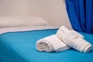 a rolled up white towel on a bed at JERA Holiday Collection VULCANO UNO - Garden View in Vulcano