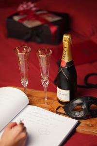 a table with a bottle of champagne and two glasses at Magik Love Apartament in Piła