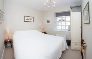 a white bedroom with a white bed and a window at St Margarets Mews in Durham