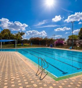 a swimming pool with a metal chair next to it at Nes Ammim Hotel in Nes Ammim