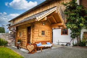a wooden house with a couch and a bench at Vorderkasbichlhof in Saalfelden am Steinernen Meer