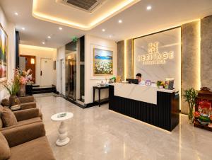 a man sitting at a reception desk in a hotel lobby at Emissary Corner Hanoi Hotel & Spa in Hanoi
