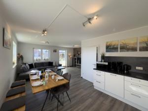 a kitchen and living room with a table and a couch at Friese24 in Wangerland