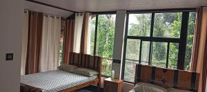 a bedroom with a bed and a large window at Mount Star Home Stay in Kakkabe +34 photos