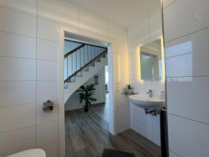 a bathroom with a sink and a staircase at Friese24 in Wangerland +45 photos