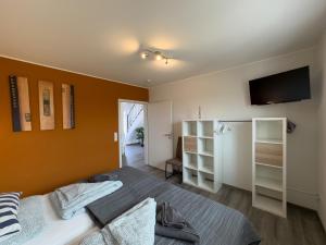 a bedroom with a bed and a flat screen tv at Friese24 in Wangerland