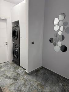 a laundry room with a washer and a washing machine at Adinna Residence in Giroc