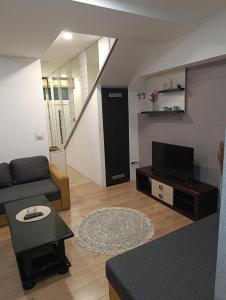 a living room with a couch and a tv at Apartman Centar 2 in Kruševac