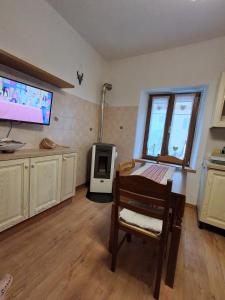 a kitchen with a table and a tv in a room at Cà Gianarín Authentic Dolomites Escape in Bocenago +1 photo