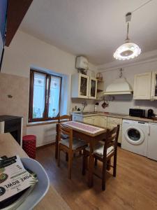 a kitchen with a table and chairs in a room at Cà Gianarín Authentic Dolomites Escape in Bocenago