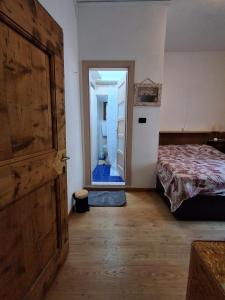 a bedroom with a door leading to a bathroom at Cà Gianarín Authentic Dolomites Escape in Bocenago