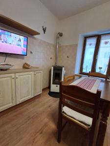 a living room with a television and a stove at Cà Gianarín Authentic Dolomites Escape in Bocenago