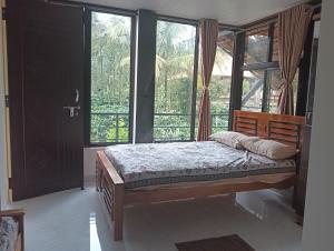 a bedroom with a bed in a room with windows at Mount Star Home Stay in Kakkabe