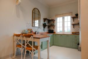 a kitchen with green cabinets and a wooden table at Suka Village 