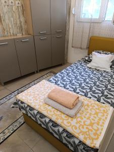 a bedroom with a bed with towels on it at Apartman Centar 2 in Kruševac