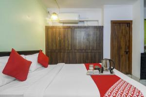 a bedroom with a large bed with red pillows at Hotel O RR in Kondapur +36 photos