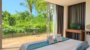 a bedroom with a bed and a large window at Villa Monsoon in Nathon Bay