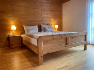 a bed in a room with a wooden wall at Schmid in Oberdrum in Oberlienz