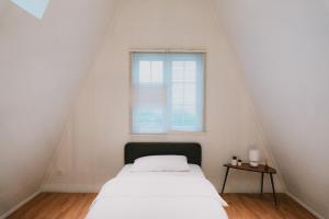 a white bedroom with a bed and a window at Suka Village  +76 photos