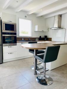 a kitchen with a table and a chair in it at Villa Métisse Ile et Villas Groix in Groix +11 photos