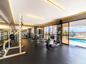 a gym with cardio equipment and a swimming pool at Grand Mercure SP Itaim Bibi in São Paulo +175 photos
