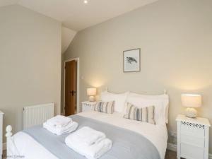a bedroom with a bed with white sheets and pillows at Fisherbridge Cottage in Weymouth