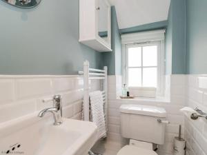 a bathroom with a toilet and a sink and a window at Fisherbridge Cottage in Weymouth +17 photos