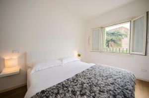 - une chambre blanche avec un grand lit et une fenêtre dans l'établissement Ca' degli Armati, à Noale