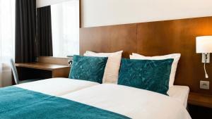 a bedroom with a bed with green and white pillows at Hotel Raumanlinna in Rauma