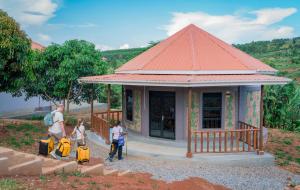 a group of people standing in front of a small building at Gejja Cottage in Lwanga
