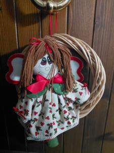 a doll ornament is hanging from a basket at Dolce casa in Saone