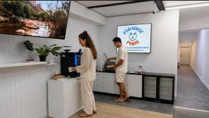 a man and a woman standing in a kitchen at Paradise Pods in Gold Coast